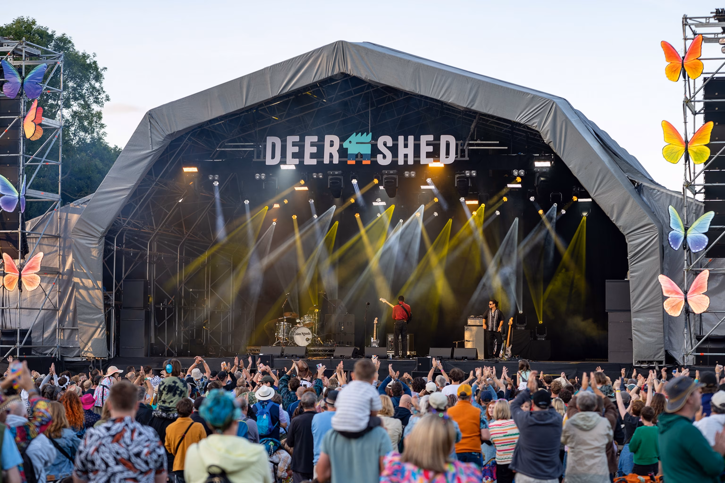 Folk myldrer omkring en udendørs scene på Deer Shed-musikfestivalen nær Ripon i North Yorkshire