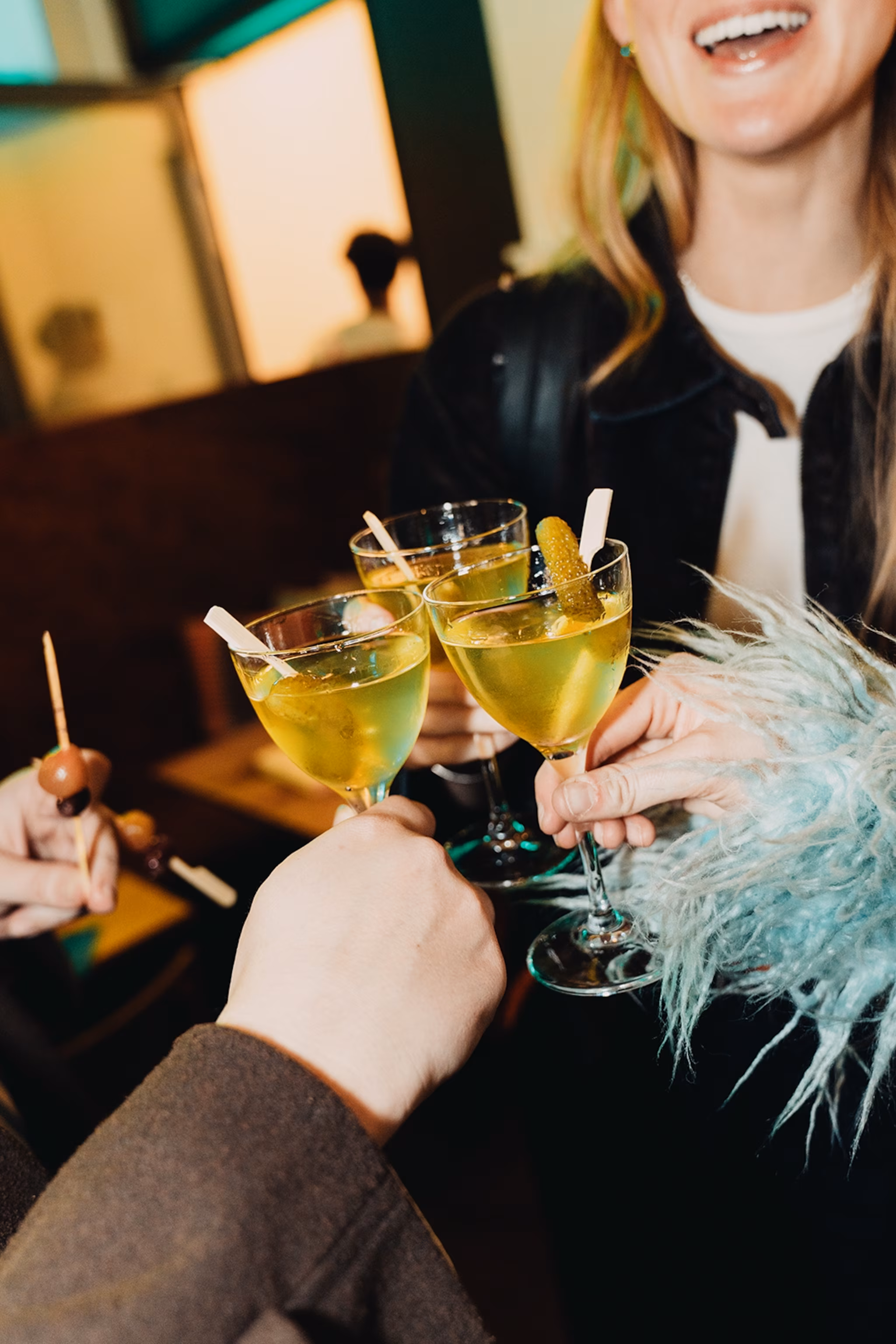Folk skåler i glas med pickle-tema drinks.