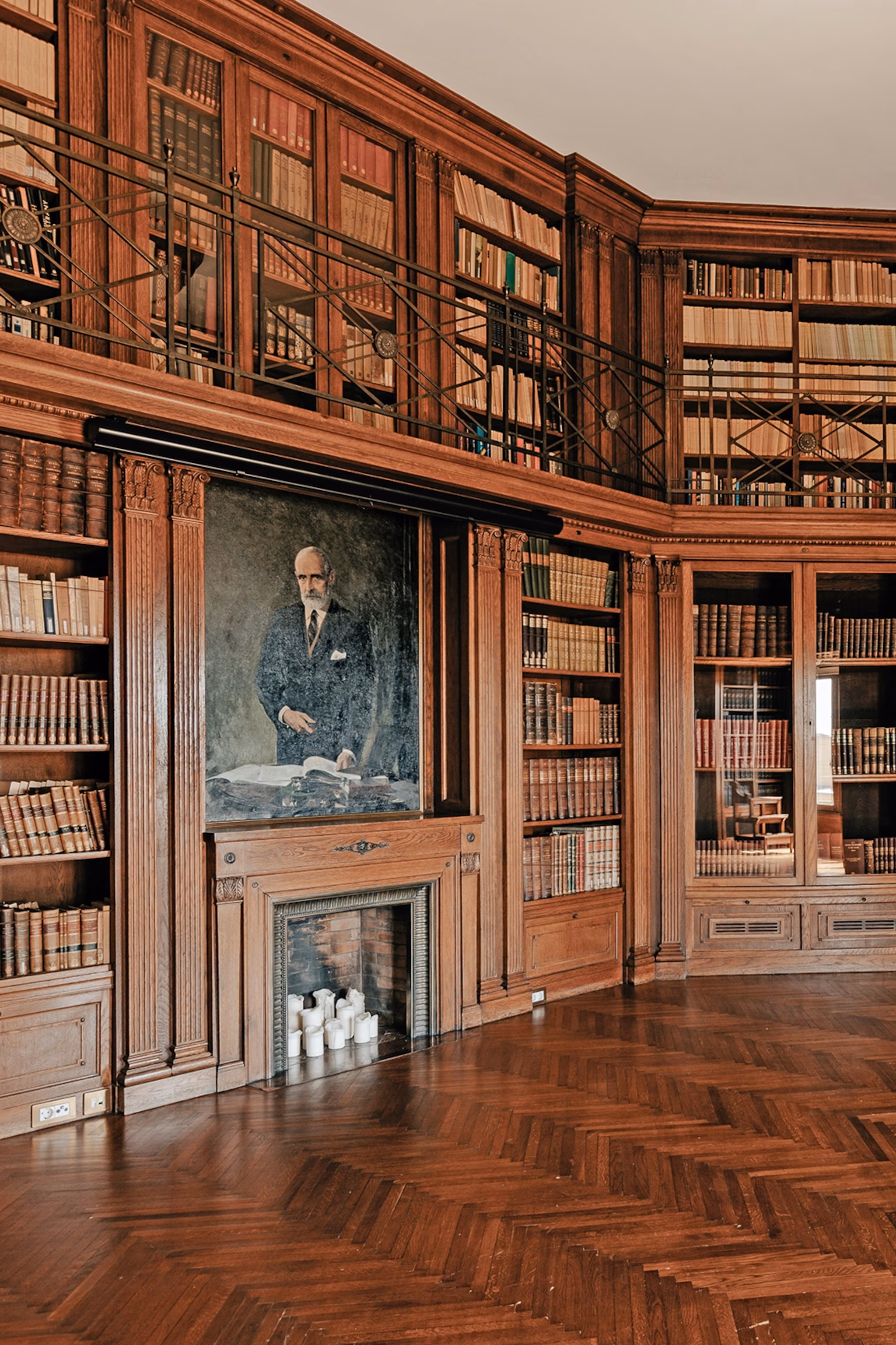 Et bibliotek i træ og flere niveauer med pejs og portræt af politikeren Francesc Cambó.