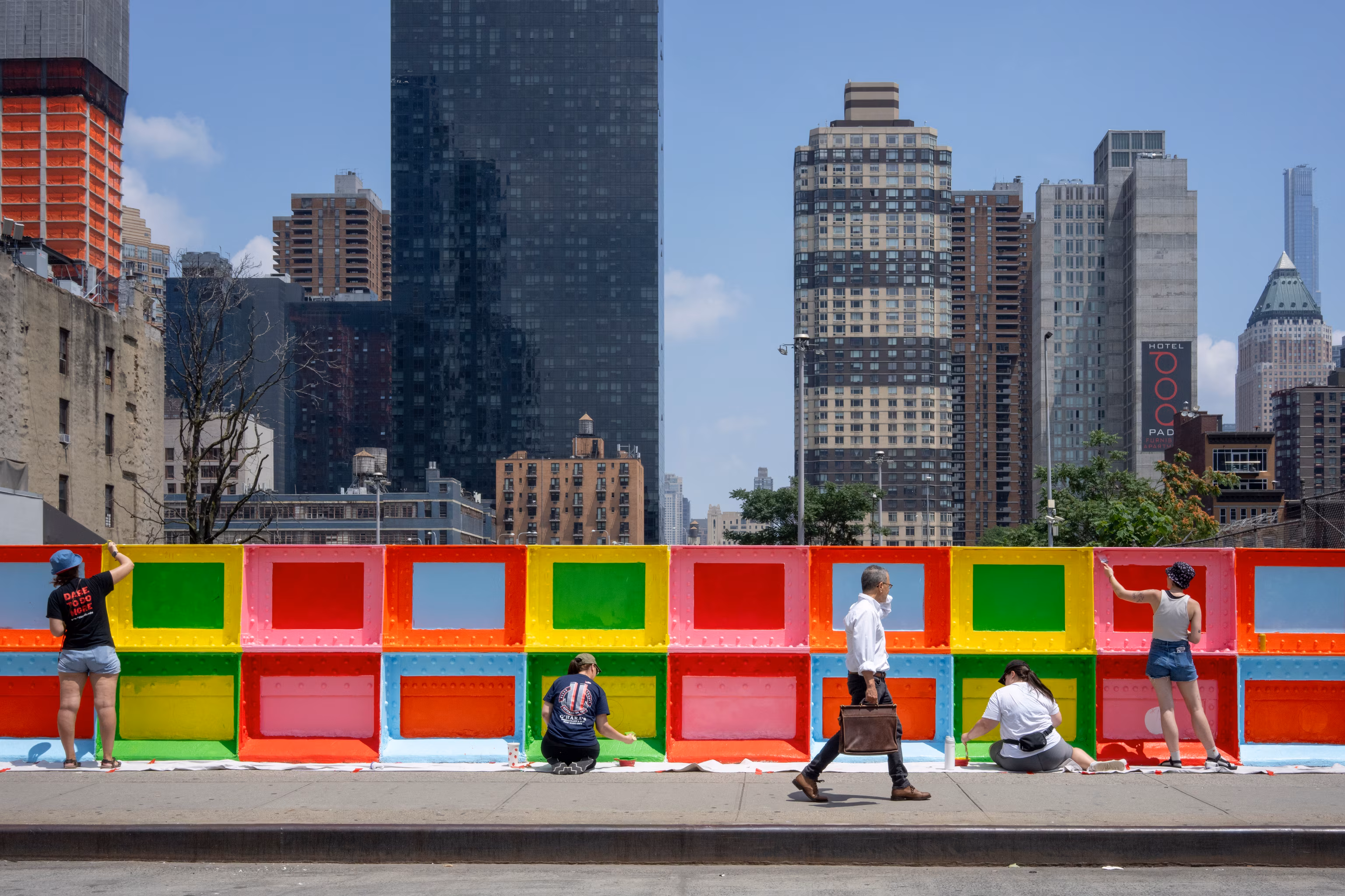 Folk går forbi en farverig mur i NYC