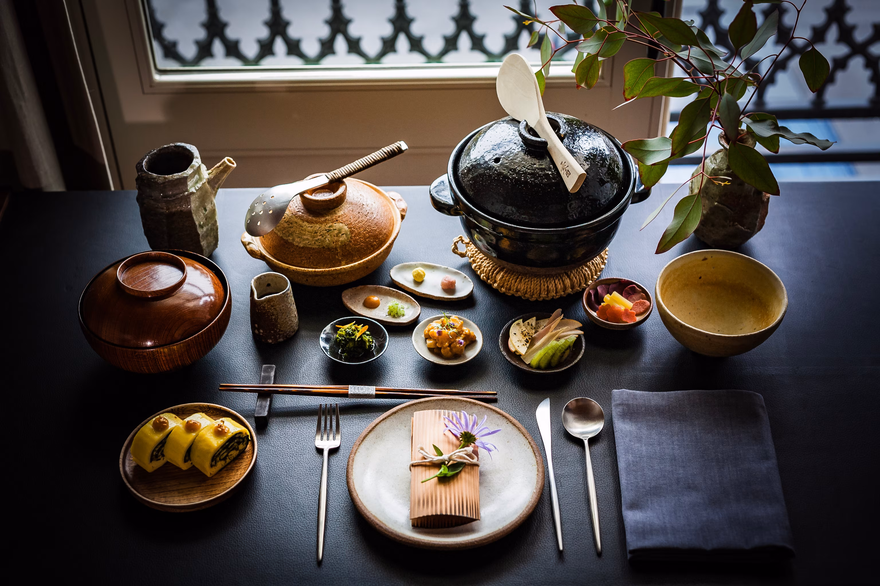 En japansk morgenmadsmenu med flere små retter og te.