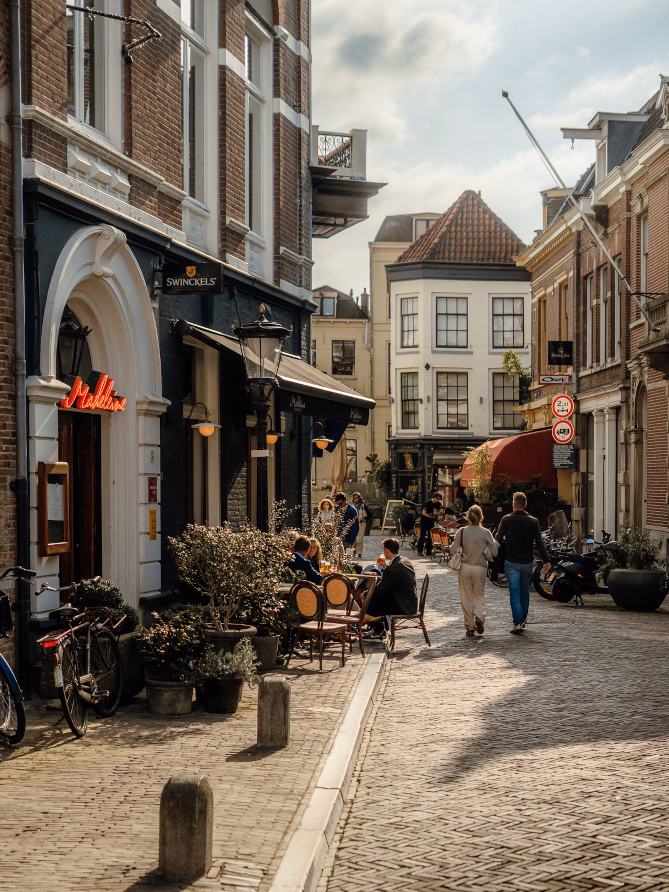 En solbeskinnet brostensbelagt gade i Utrecht, Holland.